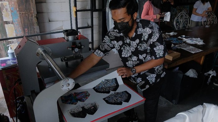 KERAJINAN MASKER LOKAL TEMBUS PASAR EKSPOR Perajin menunjukkan desain masker bergambar burung Garuda yang sempat viral di media sosial setelah masker dengan gambar yang sama digunakan oleh artis Cinta Laura di Kitasatubali, Badung, Bali, Jumat (20/8/2021). Desain masker kain yang menampilkan gambar dari karya lukisan para seniman lokal Bali, Yogyakarta, Badung, dan Jakarta dengan teknik printing tersebut menembus pasar ekspor di sejumlah negara dengan harga jual Rp45.000 - Rp125.000 per set. ANTARA FOTO/Nyoman Hendra Wibowo/hp.