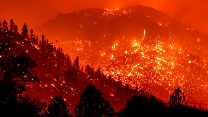 In this long exposure photo, embers light up hillsides as the Dixie Fire burns near Milford in Lassen County, Calif., on Tuesday, Aug. 17, 2021. (AP Photo/Noah Berger)