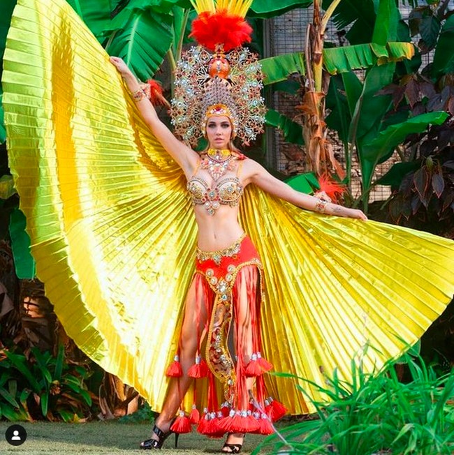 Menyusul kemudian Dana Tomuta dari Spanyol dengan kostum bergaya karnaval dalam kombinasi warna kuning dan merah yang mencolok. (Foto: Instagram)