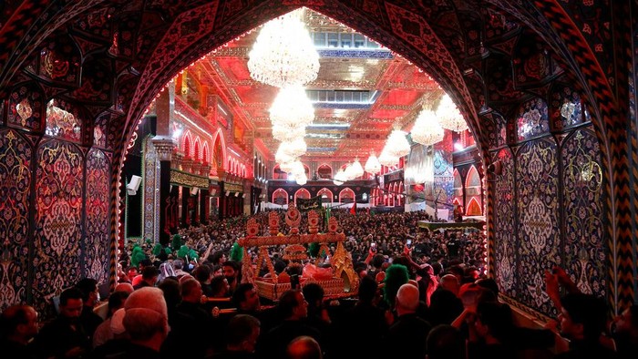 Pakistan Asyura Shiite Muslim worshippers pray outside the holy shrine of Imam Hussein, in the background, during a Muharram procession in Karbala, Iraq, early Thursday, Aug. 19, 2021. Muharram, the first month of the Islamic calendar, is a month of mourning for Shiites in remembrance of the death of Hussein, the grandson of the Prophet Muhammad, at the Battle of Karbala in present-day Iraq in the 7th century. (AP Photo/Anmar Khalil)