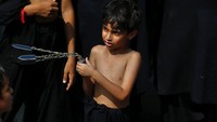 Anak-anak juga tidak mau ketinggalan dalam peringatan itu. AP/Arshad Butt