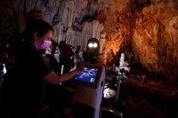Persephone memandu para pengunjung di dalam gua Alistrati, sekitar 135 kilometer (84 mil) timur laut Thessaloniki, Yunani, Senin, 2 Agustus 2021. Persephone, yang disebut-sebut sebagai robot pertama di dunia yang digunakan sebagai pemandu wisata di dalam gua, telah menyambut pengunjung ke gua Alistrati, sejak pertengahan Juli. (AP Photo/Giannis Papanikos)