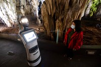 Persephone memandu para pengunjung di dalam gua Alistrati, sekitar 135 kilometer (84 mil) timur laut Thessaloniki, Yunani, Senin, 2 Agustus 2021. Persephone, yang disebut-sebut sebagai robot pertama di dunia yang digunakan sebagai pemandu wisata di dalam gua, telah menyambut pengunjung ke gua Alistrati, sejak pertengahan Juli. (AP Photo/Giannis Papanikos)