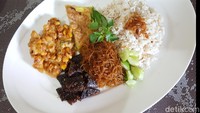Racikan nasi khas Betawi dikenal dengan nama nasi ulam. Nasinya diaduk dengan bumbu kacang kelapa lalu dilengkapi dengan dendeng, perkedel dan bihun goreng. Kalau mau bikin sendiri kamu bisa lihat resepnya di sini.  Foto: detikfood/odilia