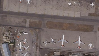 Banyak yang kemudian nekat terbang di roda atau sisi pesawat lainnya dan jatuh korban jiwa. Foto: AP/Planet Labs Inc.