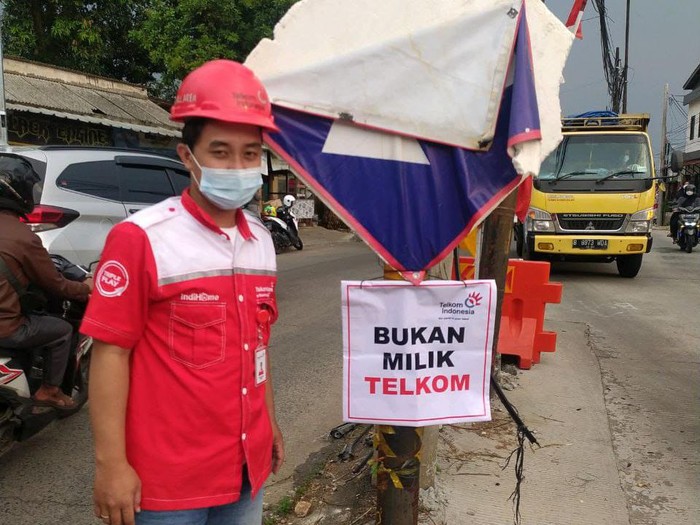Telkom menandai tiang-tiang di badan Jl Erha Depok, menyatakan bahwa tiang-tiang ini bukan miliknya. (Dok Telkom)
