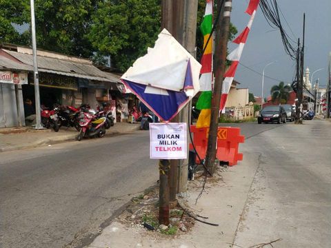 Telkom menandai tiang-tiang di badan Jl Erha Depok, menyatakan bahwa tiang-tiang ini bukan miliknya. (Dok Telkom)