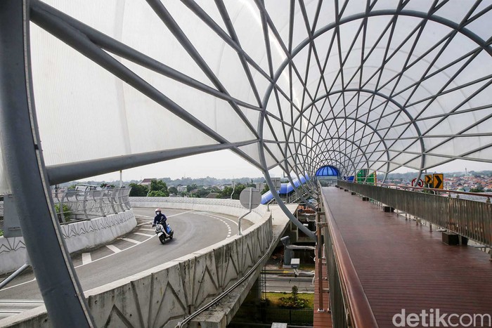 sejumlah warga tampak menyeberang melewati Jembatan Penyebrangan Orang (JPO) Lenteng Agung, Jakarta Selatan, Sabtu (21/8/2021).