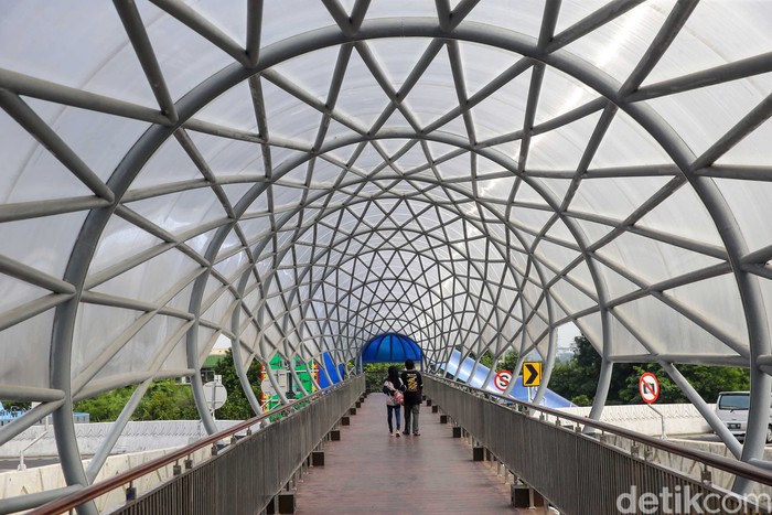 Melihat JPO Lenteng Agung yang Sudah Rampung sejumlah warga tampak menyeberang melewati Jembatan Penyebrangan Orang (JPO) Lenteng Agung, Jakarta Selatan, Sabtu (21/8/2021).