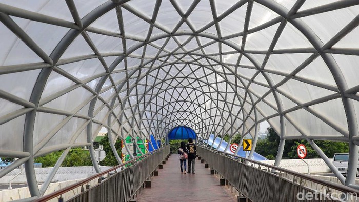 sejumlah warga tampak menyeberang melewati Jembatan Penyebrangan Orang (JPO) Lenteng Agung, Jakarta Selatan, Sabtu (21/8/2021).