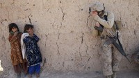 Tentara perempuan dari marinir AS, Kopral Catherine Broussard mencoba berkomunikasi dengan bocah Afghanistan di Boldoc, Provinsi Afghanistan (23/11/2010).  (Paula Bronstein/Getty Images)