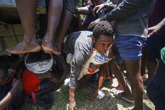 Residents overtake a truck loaded with relief supplies in Vye Terre, Haiti, Friday, Aug. 20, 2021. Private aid and shipments from the U.S. government and others were arriving in the country's southwestern peninsula that was struck by a 7.2 magnitude quake on Aug. 14. (AP Photo/Fernando Llano)