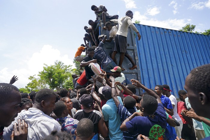 Residents overtake a truck loaded with relief supplies in Vye Terre, Haiti, Friday, Aug. 20, 2021. Private aid and shipments from the U.S. government and others were arriving in the country's southwestern peninsula that was struck by a 7.2 magnitude quake on Aug. 14. (AP Photo/Fernando Llano)