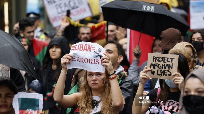 Protesters hold up placards at a march in solidarity with the people of Afganistan, in central London on August 21, 2021. (Photo by Tolga Akmen / AFP)