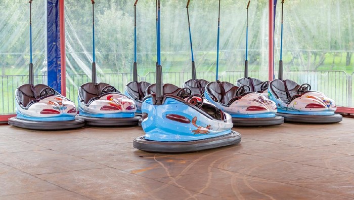 Attraction in the city summer park. Vacant electric colorful cars for kids