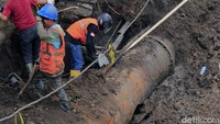 Pekerja tengah memperbaiki pipa PDAM yang pecah di Jalan Riau (LLRE Martadinata), Minggu (22/8).