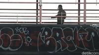 Pejalan kaki menyebrang di JPO Jalan Margonda Raya, Depok, tempat billboard digital yang bertuliskan sosialisasi pendemi COVID-19, Minggu (22/08/2021).