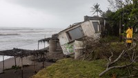 Rumah-rumah yang berada di tepi pantai tampak rusak diterjang badai.