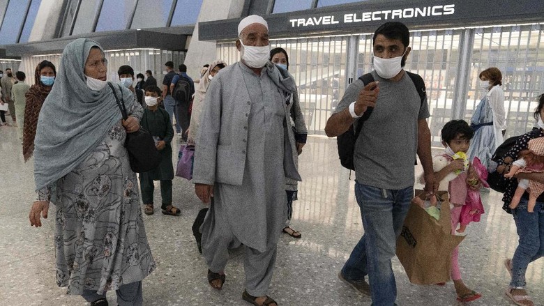 Momen Haru saat Warga Afghanistan Dievakuasi ke Washington Families evacuated from Kabul, Afghanistan, are loaded into a buses after they arrived at Washington Dulles International Airport, in Chantilly, Va., on Saturday, Aug. 21, 2021. (AP Photo/Jose Luis Magana)