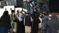Warga yang dievakuasi dari Afghanistan masuk ke dalam bus setelah mereka mendarat di Bandara Internasional Washington Dulles.
