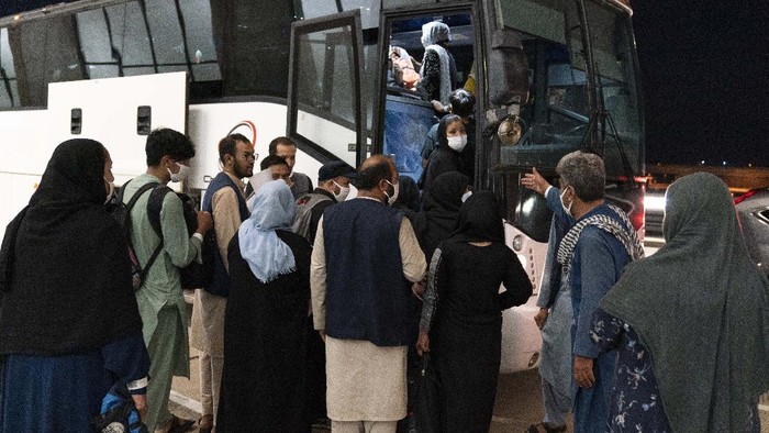 Families evacuated from Kabul, Afghanistan, are loaded into a buses after they arrived at Washington Dulles International Airport, in Chantilly, Va., on Saturday, Aug. 21, 2021. (AP Photo/Jose Luis Magana)