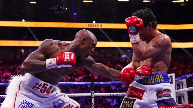 Yordenis Ugas, right, of Cuba, hits Manny Pacquiao, of the Philippines, in a welterweight championship boxing match Saturday, Aug. 21, 2021, in Las Vegas. (AP Photo/John Locher)