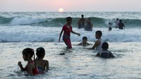 Para warga memilih pantai untuk mendinginkan diri dengan air laut. 