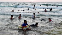 Warga Palestina duduk menikmati pantai kamp pengungsi Deir el-Balah di Laut Mediterania, Jalur Gaza tengah. 