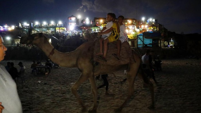 Pantai Gaza Diserbu Warga Palestina Palestinians swim on the Mediterranean Sea during the sunsets near Deir el-Balah refugee camp, central Gaza Strip, Friday, Aug. 20, 2021. (AP Photo/Adel Hana)