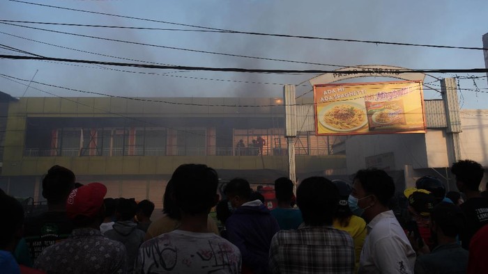 Petugas Dinas Pemadam Kebakaran Kota Surabaya melakukan pembasahan Pasar Kembang yang terbakar di Surabaya, Jawa Timur, Minggu (22/8/2021). Sekitar 23 kendaraan pemadam kebakaran dikerahkan untuk memadamkan kebakaran pasar tradisional yang meludeskan lapak-lapak di lantai dua di pasar tersebut. ANTARA FOTO/Didik Suhartono/foc.