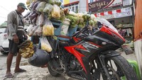 Pedagang sayur keliling Budi (63) berjualan di depan emperan toko, Entrop, Kota Jayapura, Papua, Minggu (22/8/2021). Budi sehari-hari beraktivitas sebagai pedagang sayur keliling gunakan motor sport Honda CBR 6 speed dengan harga puluhan juta rupiah.  