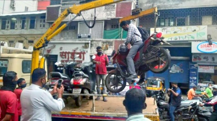 Pengendara motor nekat tetap berada di motor meski sedang diangkut crane