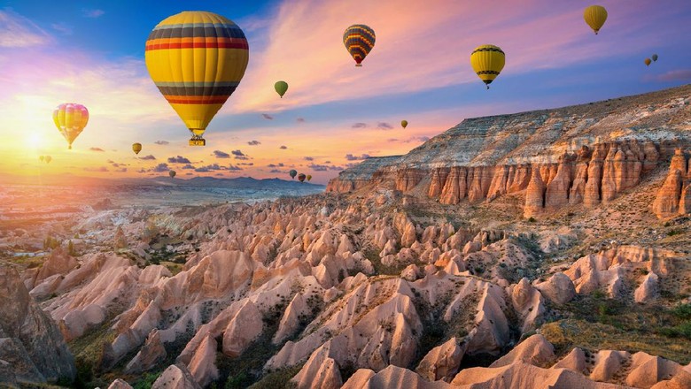 Balon udara saat sunset di Red Valley, Gerome, Turki Hot air balloons and Red valley at sunset in Goreme, Cappadocia in Turkey.