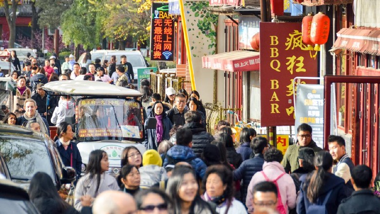 Beijing Beijing, China - November 19, 2016: Typical crowded hutong street in Beijing, China. Photo taken during the day and contains many people.