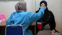 Petugas mengecek suhu ibu hamil sebelum disuntik vaksin di Puskesmas Kecamatan Cilandak, Jakarta Selatan.
