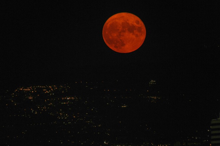 The full moon rises over Rome, Sunday, Aug.22, 2021. (AP Photo/Alessandra Tarantino)