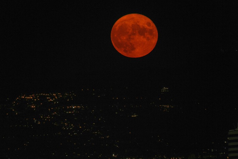 The full moon rises over Rome, Sunday, Aug.22, 2021. (AP Photo/Alessandra Tarantino)