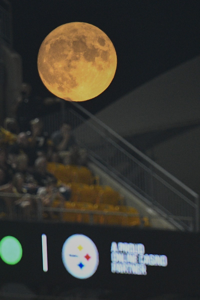 A full moon rises as fans watch the second half of an NFL preseason football game between the Pittsburgh Steelers and the Detroit Lions, Saturday, Aug. 21, 2021, in Pittsburgh. (AP Photo/Don Wright)