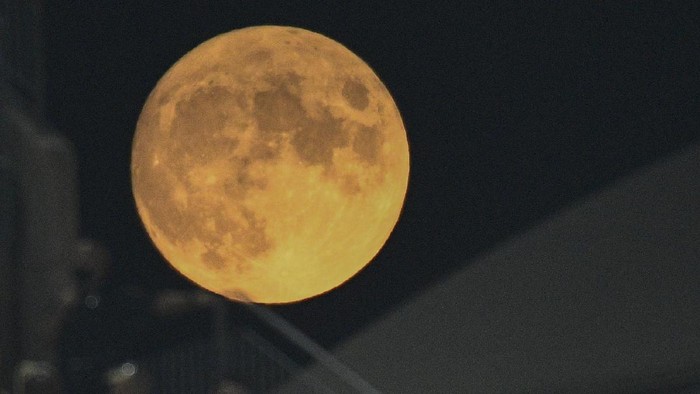 A full moon rises as fans watch the second half of an NFL preseason football game between the Pittsburgh Steelers and the Detroit Lions, Saturday, Aug. 21, 2021, in Pittsburgh. (AP Photo/Don Wright)