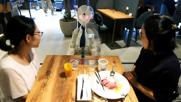 Seorang pelayan di kafe Tokyo menyapa pelanggan dari ratusan kilometer jauhnya. Ya, perantaranya adalah sebuah robot. (Behrouz Mehri/AFP)