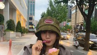 Berada di sebuah pinggir jalan, Lisa tampak manis berpose dengan satu cone es krim rasa stroberi. Ia tampak menikmati sekali. Foto: Instagram @lalalalisa_m