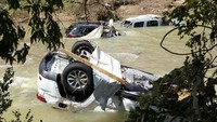 Mobil ini menungging setelah dibawa arus banjir.