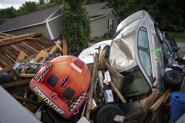 A car leans against a utility pole Sunday, Aug. 22, 2021, in Waverly, Tenn. Heavy rains caused flooding in Middle Tennessee and have resulted in multiple deaths as homes and rural roads were washed away. (AP Photo/Mark Humphrey)