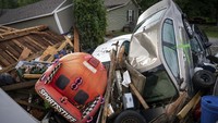 Mobil terseret dan menyatu dengan puing-puing yang terbawa arus banjir.