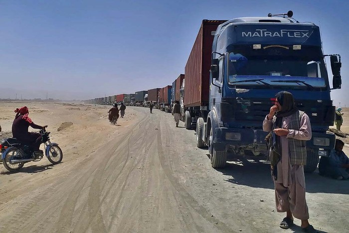 A porter pushes a wheelbarrow carrying a sick Afghan national as he and his relatives enter Pakistan through a border crossing point in Chaman, Pakistan, Monday, Aug. 23, 2021. Chaman is a key border crossing between Pakistan and Afghanistan that normally thousands cross daily along with a steady stream of trucks transporting goods to Afghanistan. (AP Photo/Jafar Khan)