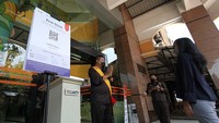 Karyawan Solo Grand Mall (SGM) mengajak pengunjung mal di jalan Slamet Riyadi, Surakarta untuk mencoba aplikasi Peduli Lindungi di lobi mal SGM, Solo, Jawa Tengah, Senin (23/8).