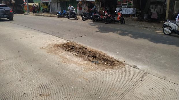 Tiang di Tengah Jl Erha Cinere Depok dicabut. Saat lubang sisa tiang ditutup tanah.
