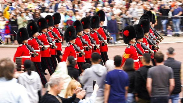Tentara dengan topi bulu beruang dan baju tunik merah berbaris di halaman Istana Buckingham di London, Inggris, pada hari Senin (23/8). Prajurit elite Pengawal Coldstream Batalyon 1 berbaris rapi sembari memanggul senjata. Mereka kembali melaksanakan tradisi Upara Pergantian Penjaga di halaman istana. 