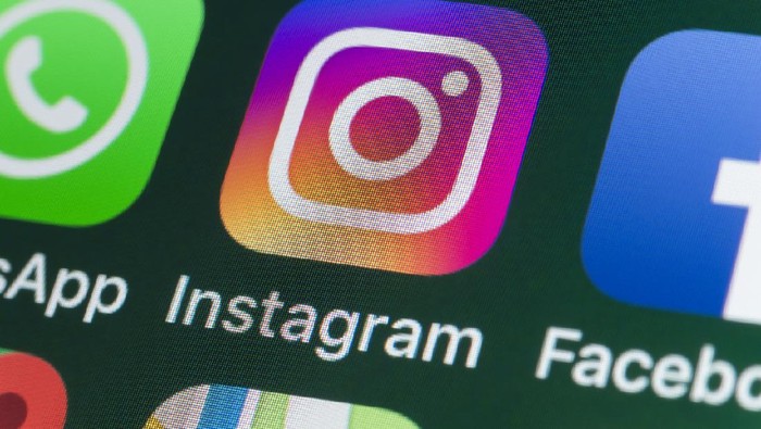 London, UK - July 30, 2018: The buttons of the photo app Instagram, surrounded by WhatsApp, Facebook, Messages and other apps on the screen of an iPhone.