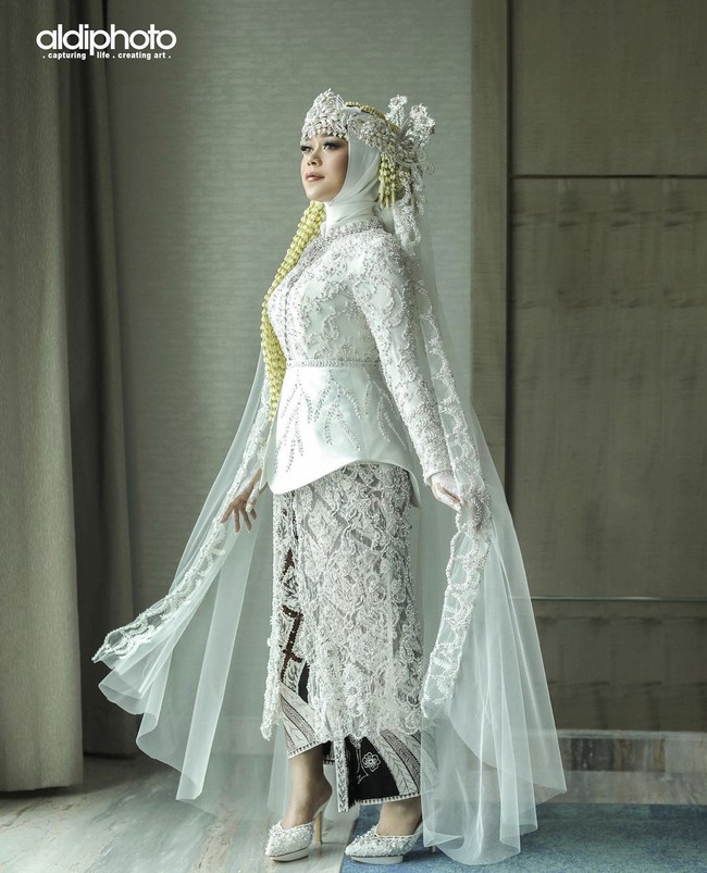 Lesti Kejora menggunakan busana adat Sunda di hari akad nikahnya. Penampilannya dilengkapi dengan hijab dan hiasan kepala siger serta ronce melati. Foto: Dok. Instagram @aldiphoto.